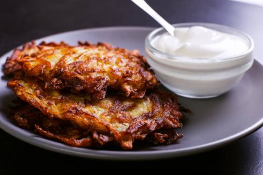 Hash brown ve ekşi krema de kızarmış karanlık bir taş zemin üzerine plaka üzerinde. Kopya alanı.