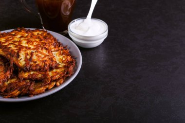 Hash brown ve ekşi krema de kızarmış karanlık bir taş zemin üzerine plaka üzerinde. Kopya alanı.