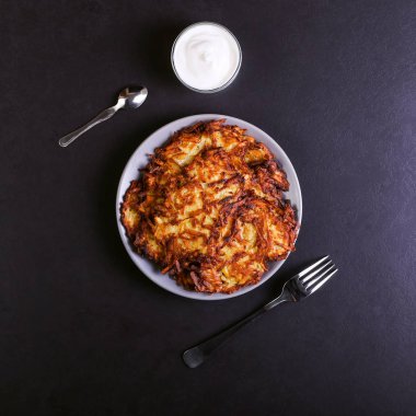 Hash brown ve ekşi krema de kızarmış karanlık bir taş zemin üzerine plaka üzerinde. Kopya alanı.