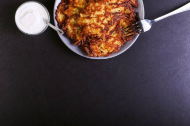 Hash brown ve ekşi krema de kızarmış karanlık bir taş zemin üzerine plaka üzerinde. Kopya alanı.