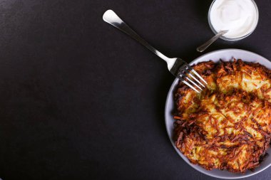 Hash brown ve ekşi krema de kızarmış karanlık bir taş zemin üzerine plaka üzerinde. Kopya alanı.