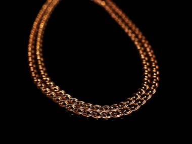 Altın zincir yansıması ile siyah arka plan üzerine sigara, dokuma. İzole, makro, yumuşak odak.