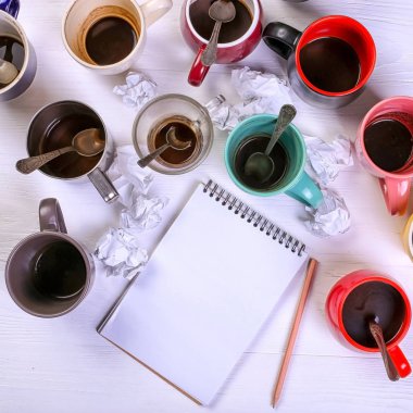 Boş kirli kahve fincanı, farklı renkler tablo ve defter mektup yazmak için. Kavram kafein uyarıcı, sorunu çözmek için enerji eksikliği. Kopya alanı.