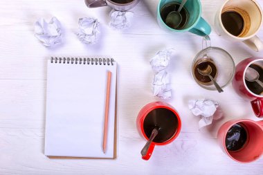 Boş kirli kahve fincanı, farklı renkler tablo ve defter mektup yazmak için. Kavram kafein uyarıcı, sorunu çözmek için enerji eksikliği. Kopya alanı.