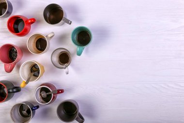 Farklı renklerde masada boş kirli kahve fincanı. Kafein uyarıcı, enerji eksikliği ve uzun süre beklemek. Kopya alanı.