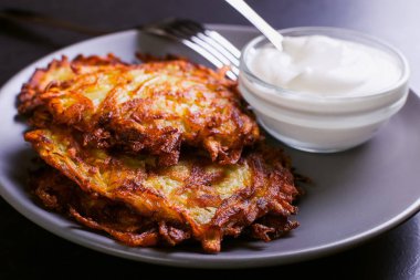 Hash brown ve ekşi krema de kızarmış karanlık bir taş zemin üzerine plaka üzerinde. Kopya alanı.