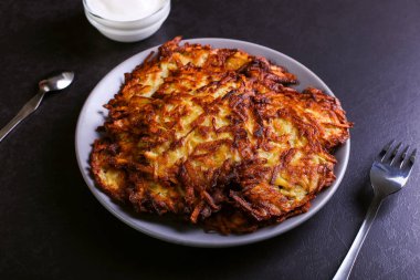 Hash brown ve ekşi krema de kızarmış karanlık bir taş zemin üzerine plaka üzerinde. Kopya alanı.