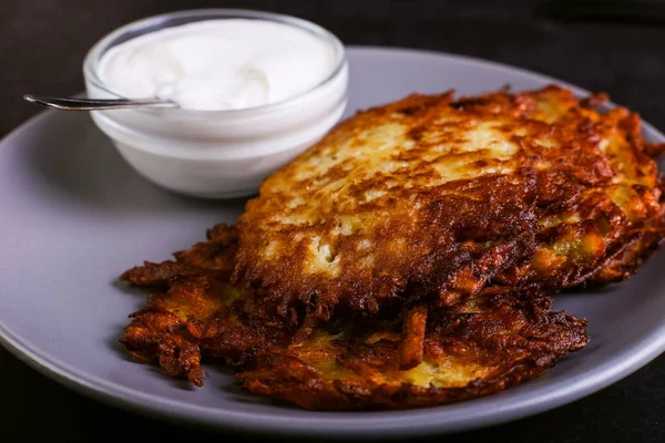Hash brown ve ekşi krema de kızarmış karanlık bir taş zemin üzerine plaka üzerinde. Kopya alanı.