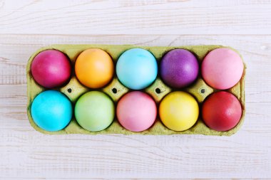Renkli Paskalya yumurtaları tavada bir beyaz ahşap tablo.