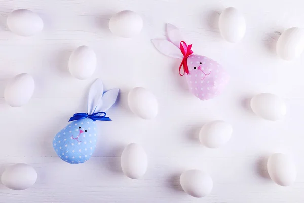 White eggs pattern, including two handmade Easter bunny, blue pink.