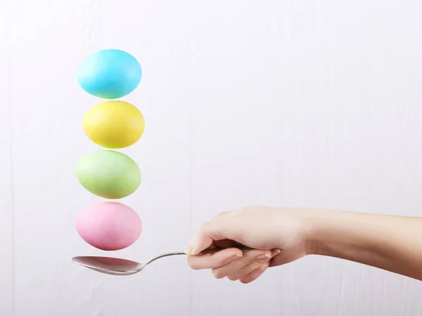 Жіноча Рука Тримає Ложку Якій Збалансовані Різнокольорові Яйця Білому Тлі — стокове фото