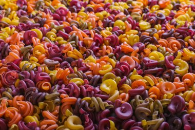 Doğal sebze boyaları ile olağandışı şeklinde bir çok renkli makarna. Arka plan.