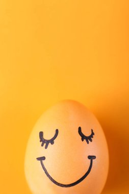 Sarı yumurta ile boyalı gülümsüyor. Mutlu Paskalyalar, konsept tebrik kartı tasarımı.