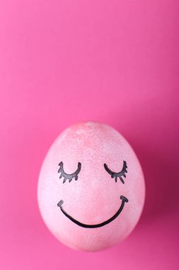 Pembe yumurta ile boyalı gülümsüyor. Mutlu Paskalya konsept tebrik kartı tasarımı.