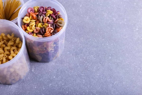 添加天然植物染料的多色面食 在混凝土桌子上的罐子里 顶部视图 复制空间 — 图库照片