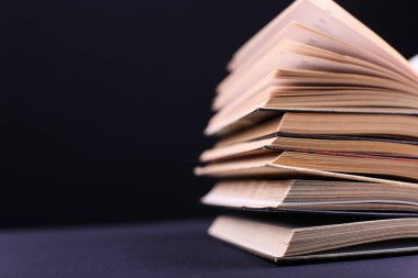 Açık kitap masaya siyah arka plan, ayrı tutulan dizilir. Okulda, bir dağ bilgi zor ev ödevi.