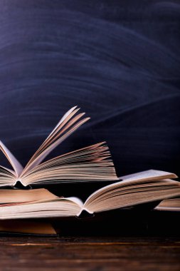 Dağ masaya bir tebeşir tahtası arka planı açık kitaplardır. Okulda, bir dağ bilgi zor ev ödevi.