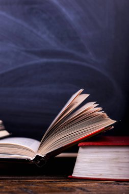 Dağ masaya bir tebeşir tahtası arka planı açık kitaplardır. Okulda, bir dağ bilgi zor ev ödevi.