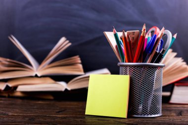 Defter, kitap açın ve kalemler tebeşir tahtası arka plan üzerinde koyu ahşap masa üzerinde durmak. Okulda, etiket kopya alanı bilgi öğrenme.