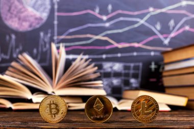 Bir kara tahta arka planı masada kitaplar çizilmiş grafik ve desenler büyümenin ve Kripto düşüş vardır. İş Eğitim Okulu cryptocurrency.
