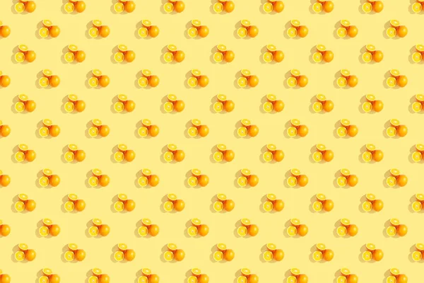 Апельсини на яскравому жовтому тлі. Повторюваний шаблон , — стокове фото