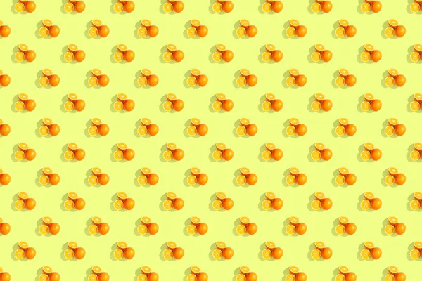 Sinaasappelen op helder gekleurde gele achtergrond. Herhalend patroon, — Stockfoto