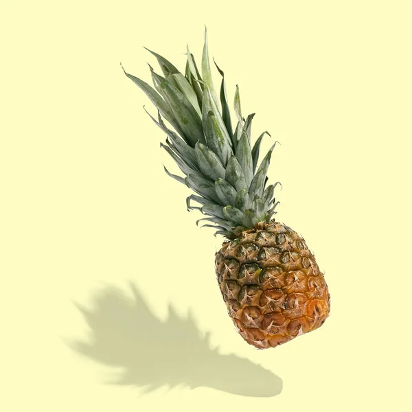 Ananas vole dans l'air sur fond lumineux disposition créative, copier l'espace. Pose plate. Impression concept alimentaire . — Photo