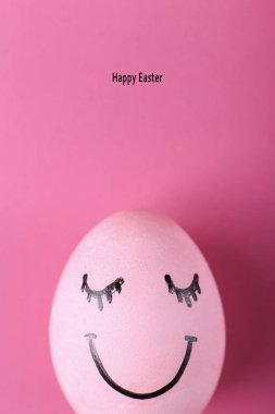 Pembe yumurta ile boyalı gülümsüyor. Mutlu Paskalya konsept tebrik kartı tasarımı.