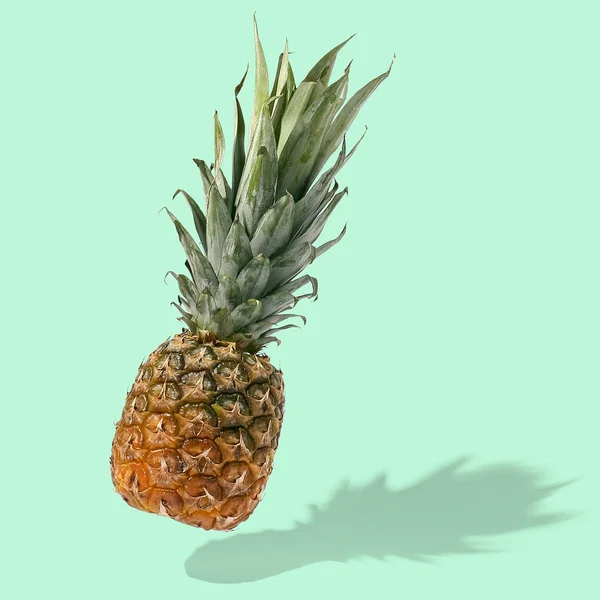 Ananas flyger i luften på ljus bakgrund kreativ layout, — Stockfoto