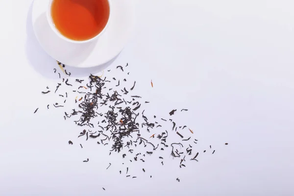 Keramische cup met thee en thee bladeren, op een witte achtergrond. De — Stockfoto