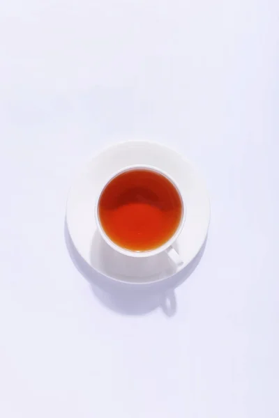 Керамическая чашка с чаем, на белом фоне. Суровая тень — стоковое фото