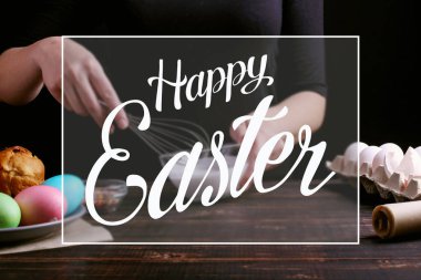 Kız Paskalya pişirme hazırlar, pasta buzlanma ile smear ve renkli toz ile sprinkles. Mutfak masasında karanlık bir arka plan üzerinde tatil için hazırlanıyor. Metin, mutlu Paskalya.