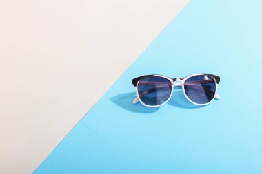 Güneş gözlüğü sert gölgeni, yaz ve gevşeme, minimalizm sanat kavramına bir renkli arka plan üzerinde yalan.