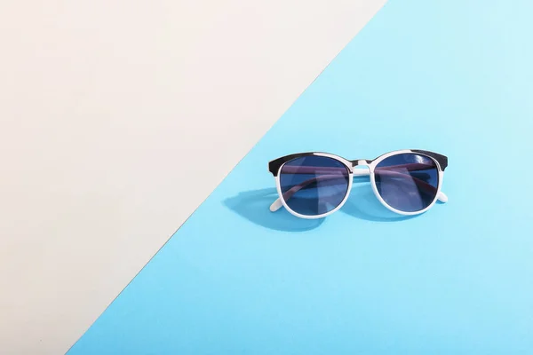 Sonnenbrillen auf farbigem Hintergrund werfen einen harten Schatten, Konzeptkunst des Sommers und der Entspannung, Minimalismus. — Stockfoto