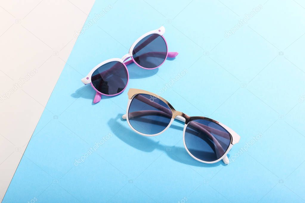 Sunglasses lie on a colored background casting a harsh shadow, concept art of summer and relaxation, minimalism.