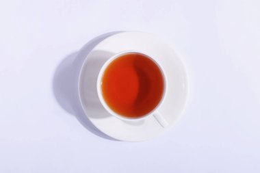 Seramik bardak çay, beyaz bir arka plan ile. Sert gölgesinde 