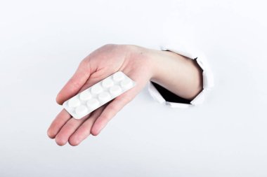 El kabarcıklar hapları ile tutarak paperman, delik dışında. Beyaz arka plan üzerinde izole.