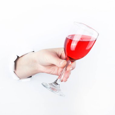Bir bardak kırmızı şarap tutan paperman, delik dışında el. Beyaz arka plan üzerinde izole.