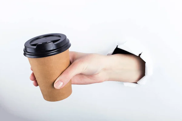 Kvinnliga ut ur hålet i paperman, håller ett brunt glas kaffe med honom. Isolera på vit bakgrund. — Stockfoto