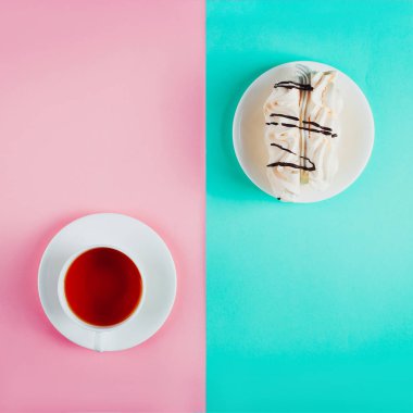Bir daire ve bir fincan çay pastel renkli kağıt arka plan üzerinde beze pasta. Kopya alanı.