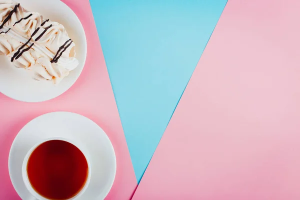 Торт безе на блюдце и чашка чая на бумажном фоне пастельного цвета. Копирование пространства . — стоковое фото