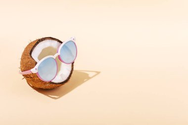 Güneş gözlüklü Sarı zemin üzerine yarım Hindistan cevizi. Gevşeme, yaz ruh hali, kopya alanı kavramı.