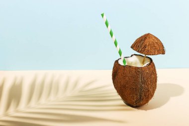 Açık bir Hindistan cevizi ve palmiye yaprakları renkli bir arka plan üzerinde gölge kokteyl. Yaz ruh, hasat.