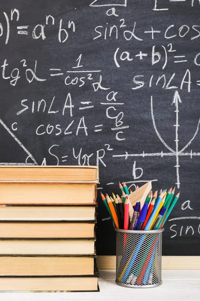 De receptie van de school in de klas, met boeken over achtergrond van krijt bord met schriftelijke formules. Soncept Teacher's dag. — Stockfoto