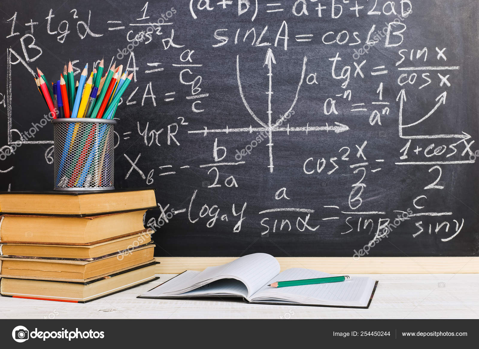 School Desk In Classroom With Books On Background Of Chalk Board