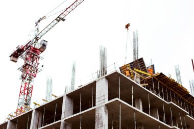 Betonarme gökdelen, işçiler ve vinç inşaatı. İşçi Bayramı kavramı.