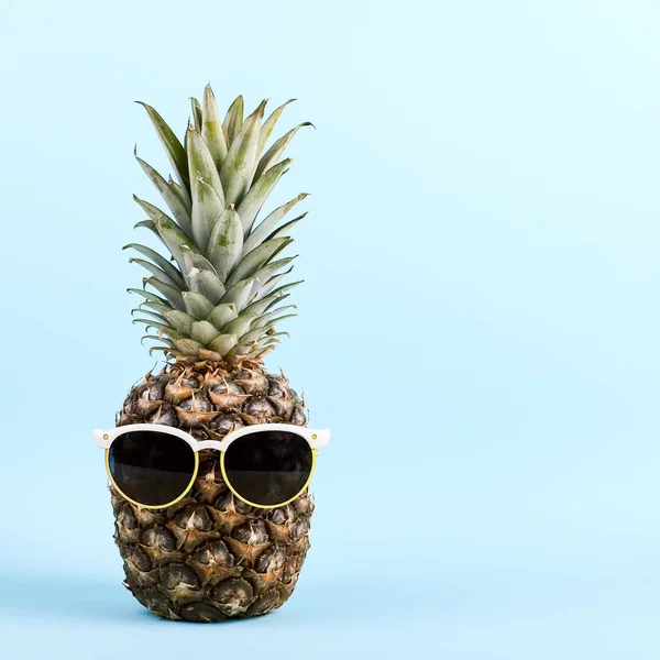 Ananas v brýle, koncept legrační letní náladu, na modrém pozadí. — Stock fotografie