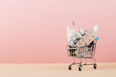 Alışveriş sepeti hapları pembe sarı arka plan üzerinde yüklü. ,