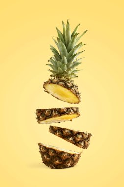 Ananas dilimlenmiş, havada levitates. Sarı bir arka planda yaz ruh kavramı.