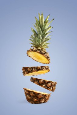 Ananas dilimlenmiş, havada levitates. Mavi bir arka planda yaz ruh kavramı.